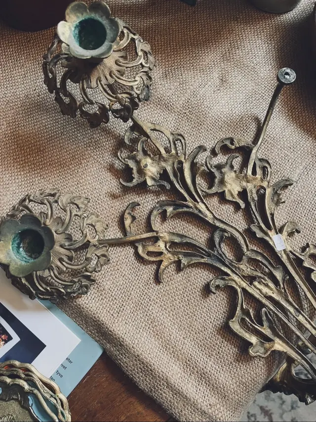 Ornamenterad ljusstake i mässing på juteduk